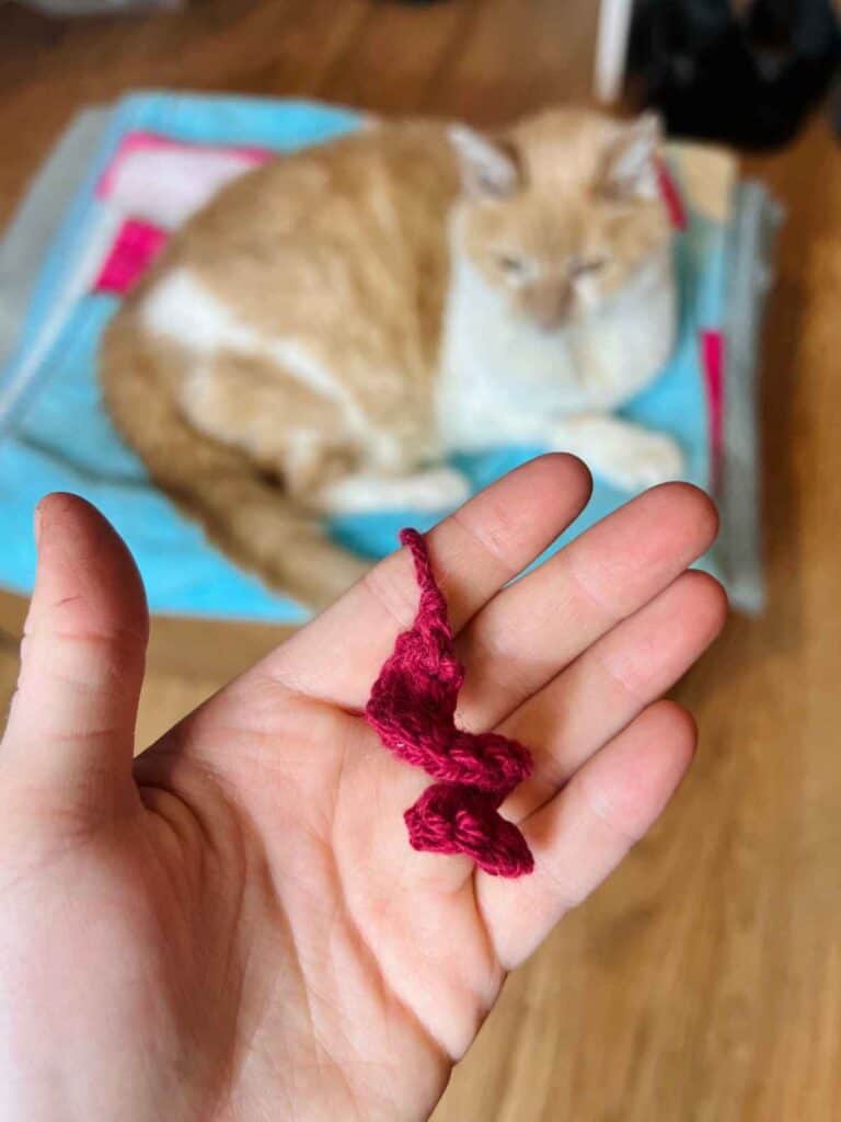 swirly crochet cat toy with cat in background